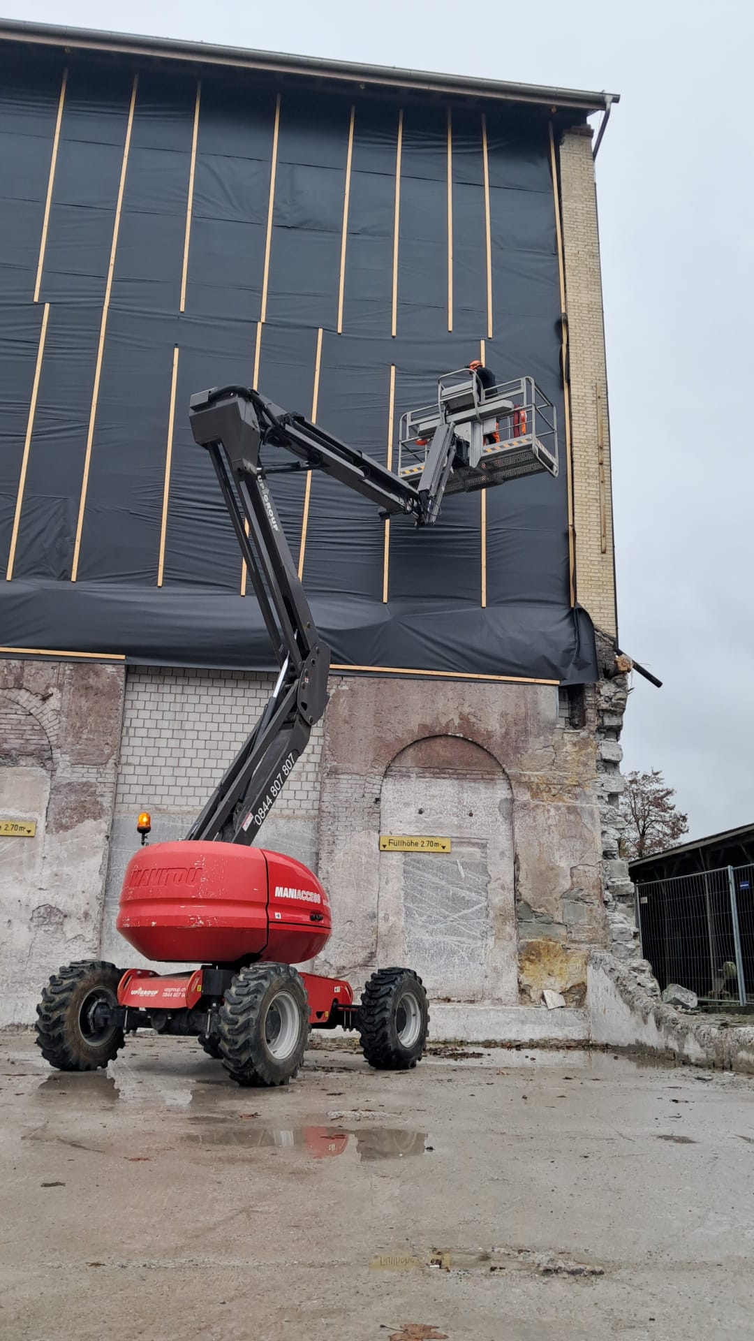 Deformationsmessungen dienen als Frühwarnsystem für Veränderungen an Gebäuden. Je nach Gebäudehöhe werden die Messprismen mit einer Hebebühne an der Fassade montiert und nach Abschluss der Arbeiten wieder demontiert.